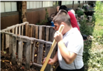 student working in the Killip Garden compost piles 
